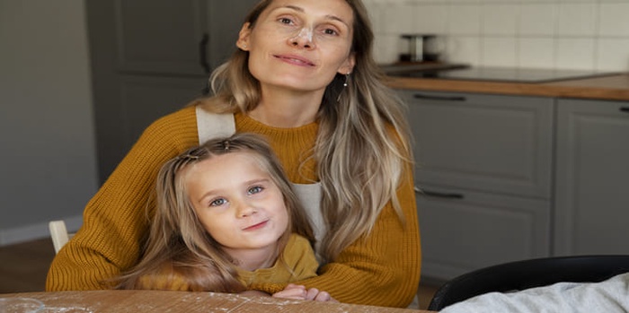 Front view smiley woman and girl at home