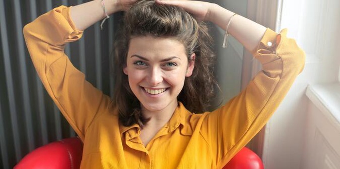 A woman wearing a yellow shirt and smiling