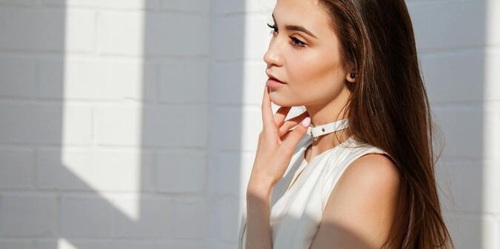 Woman in white top posing for photo