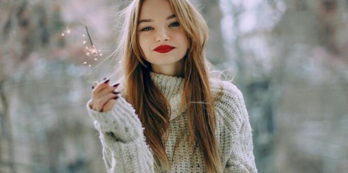 The woman is wearing a gray sweater